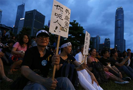 A pro-democracy protester carries a placard which reads ‘Communist Party, you lie!’.jpg