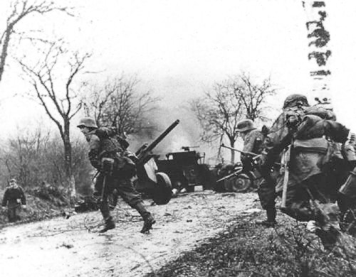 GERMAN_TROOPS_ADVANCING_PAST_ABANDONED_AMERICAN_EQUIPMENT.jpg