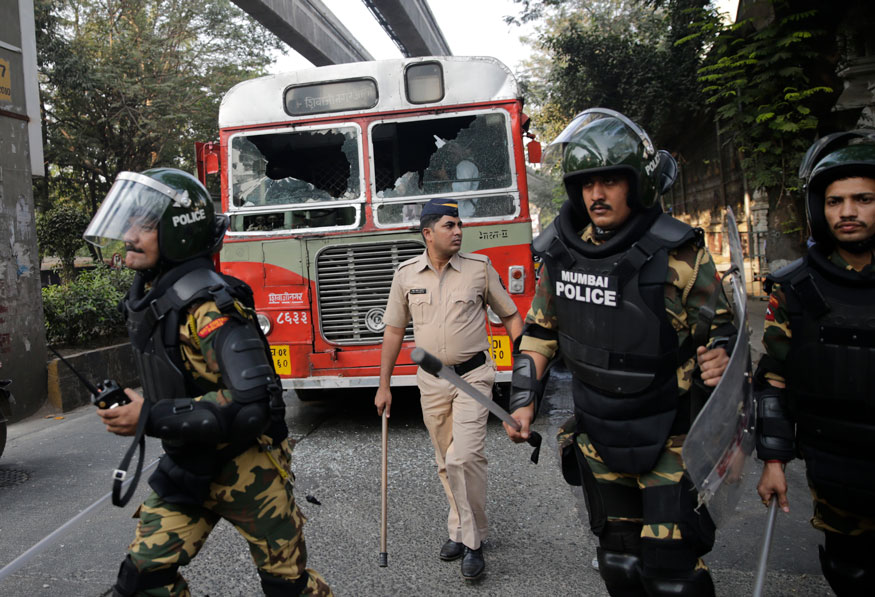 Policemen-patrol-near-a-bus-damaged.jpg