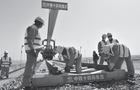 Railway workers lay tracks on the Hotan-Ruoqiang railway in the Xinjiang Uygur autonomous regi...png