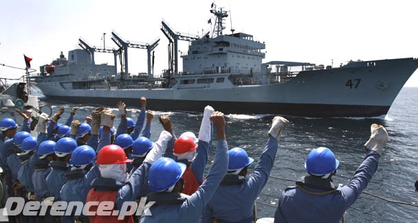 Pakistan Navy personnel raise their fists and shout slogans.