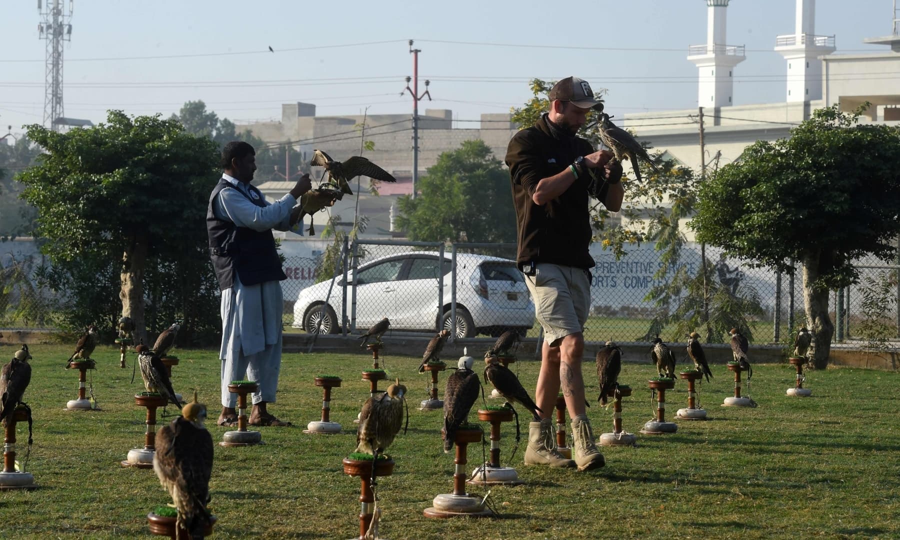 Hielko Van Rijthoven (R), a conservationist working with Wings of Change, examines a falcon seized by authorities from smugglers, in Karachi. — AFP