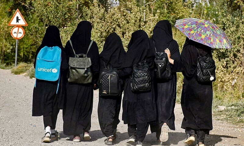 Afghan girls from a madrassa walk along a road in Balkh province’s Sholgara district on Sunday. — AFP