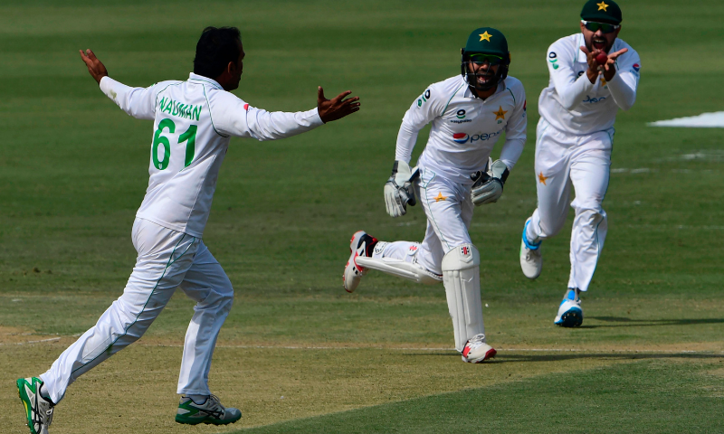 Pakistan's captain Babar Azam (R), wicketkeeper Mohammad Rizwan (C) and Nauman Ali celebrate the dismissal of South Africa's Dean Elgar during the first day of the first cricket Test match between Pakistan and South Africa at the National Stadium in Karachi on Tuesday. — AFP