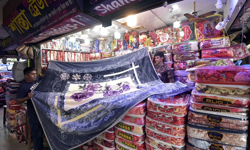 Salesmen lay out a Chinese blanket at a market in Dhaka, Bangladesh, on Nov. 23, 2022.(Photo: Xinhua)