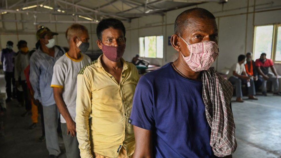 Homeless persons queue up to register and get themselves inoculated with the Covid-19 coronavirus vaccine at a shelter home in New Delhi on 28 June 2021.