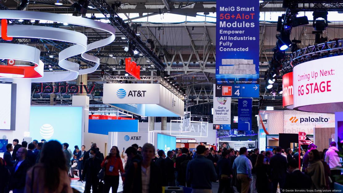 People are seen walking among booths during the first day of Mobile World Congress 2023