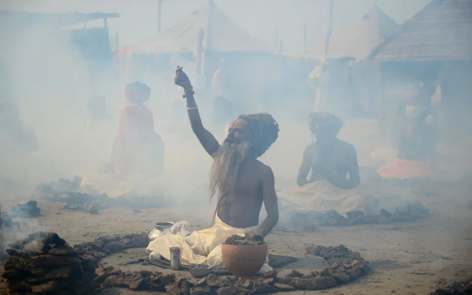 Indian Sadhus or holy men perform a ritual by burning dried cow dung cakes in earthen pots at Sangam, confluence of rivers Ganges, Yamuna, and mythical Saraswati, on the occasion of "Basant Panchami" during Magh Mela festival in Allahabad - SANJAY KANOJIASANJAY KANOJIA/AFP/Getty Images