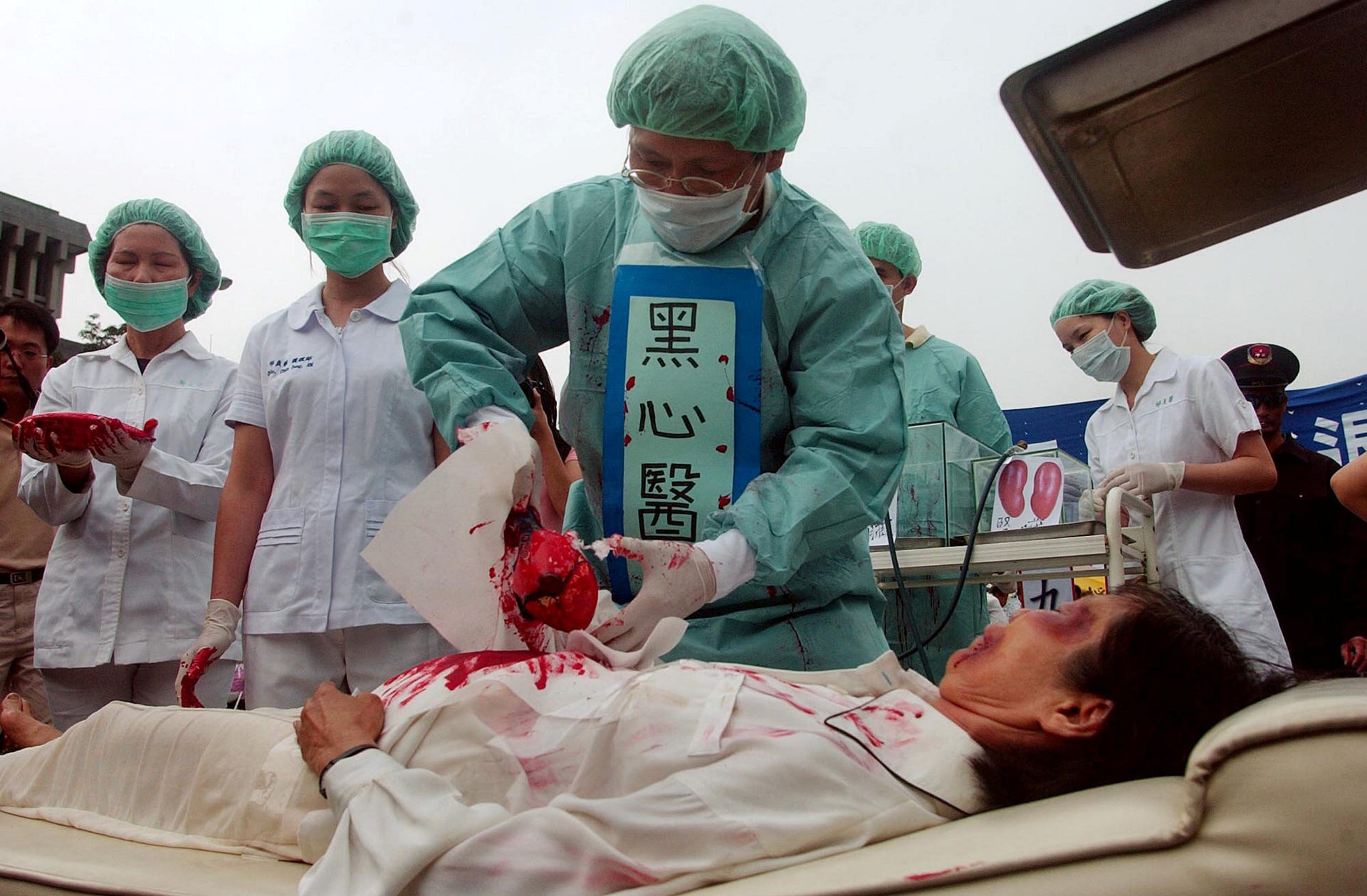 Mambers of Falun Dafa practitioners simulate organ harvesting in a mock Chinese labor camp in protest against China's suspected abuse and killing of Falun Gong members, April 23, 2006.