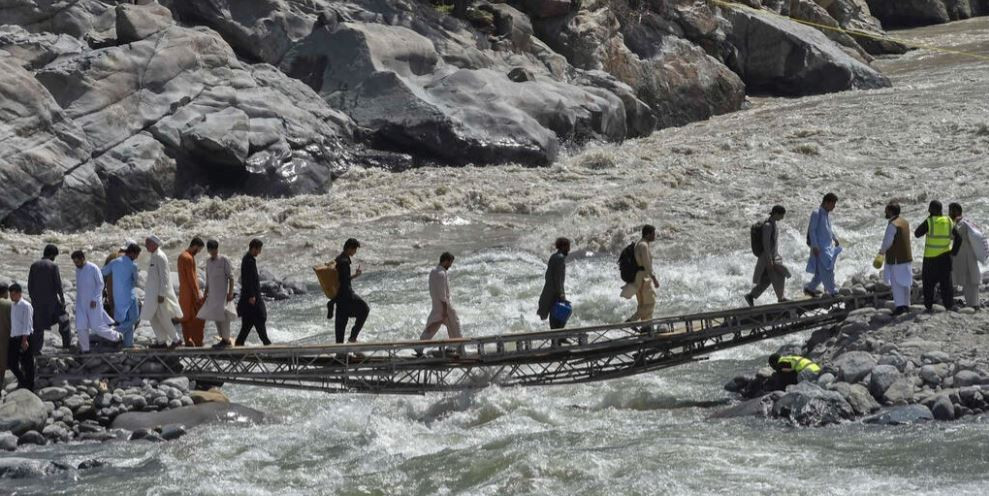 a vehicle bridge across the swat river was destroyed by a flash flood and now the only way across is by a rickety makeshift footbridge photo afp