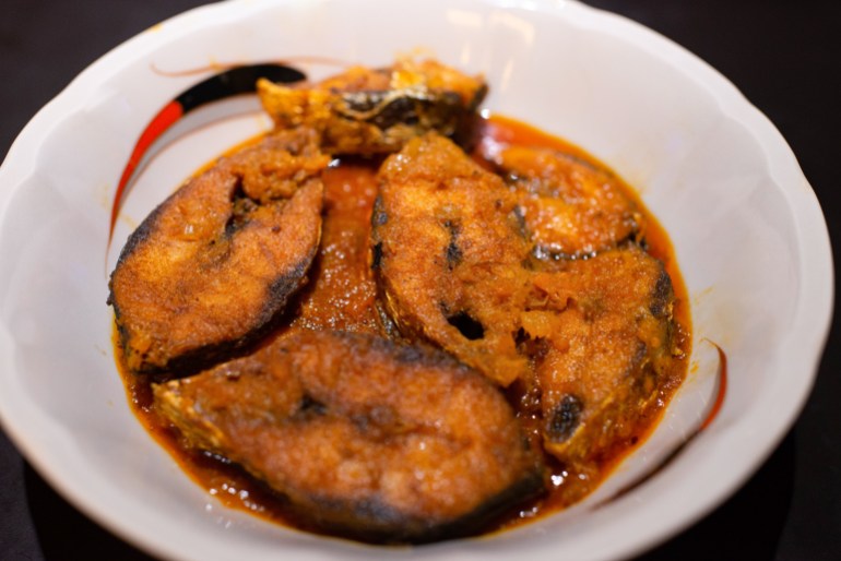 A plate of hilsa curry with pineapple