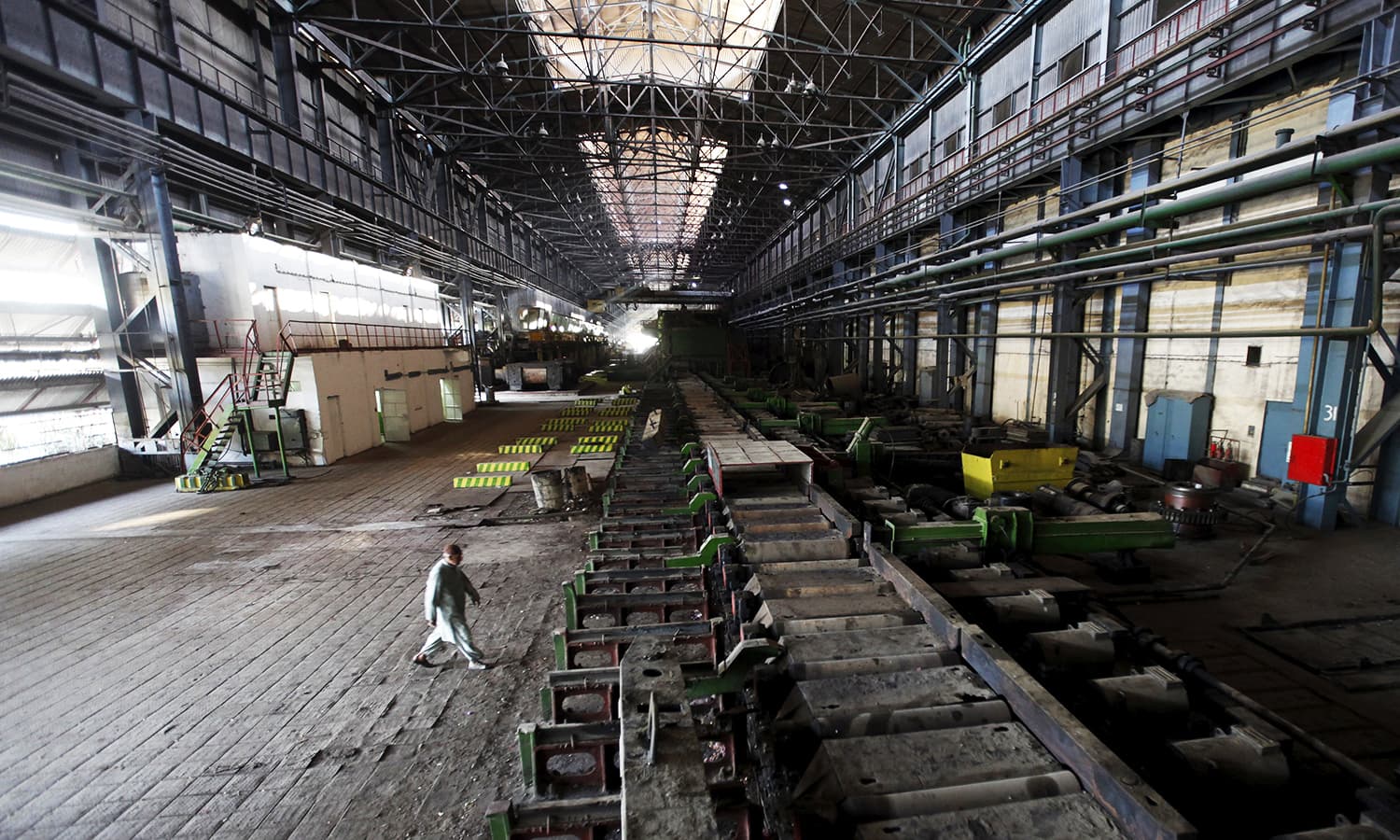 a man walks past machines at the hot strip mill department of the pakistan steel mills psm on the outskirts of karachi pakistan photo reuters