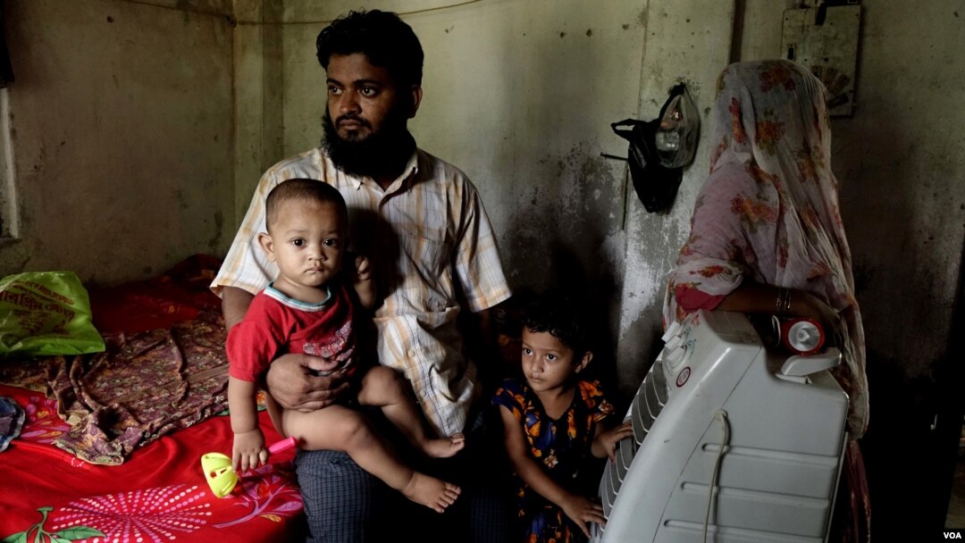 FILE - Mohammad Salim, a Rohingya Muslim refugee, with his wife and children, in a village, somewhere in India, May 27, 2019. Recently the Rohingya man was arrested and sent to jail by Indian police after he was charged as an illegal immigrant in India. (Shaikh Azizur Rahman/VOA)