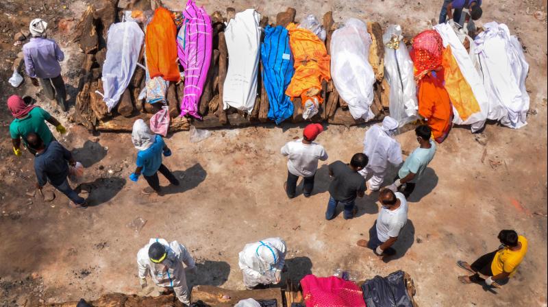 Relatives and family members perform last rites during mass cremation of COVID-19 victims, at Swar Rekha Ghat cremation ground, in Ranchi. (Photo: PTI)