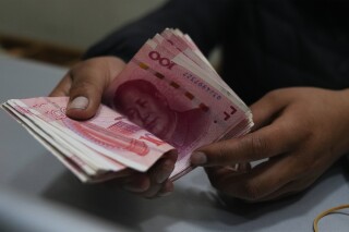 A money exchange shop worker counts Chinese yuan banknotes in La Paz, Bolivia, Wednesday, July 26, 2023. Bolivia’s state-run bank, Banco Union, has started to carry out transactions using China’s currency, the yuan. (AP Photo/Juan Karita)