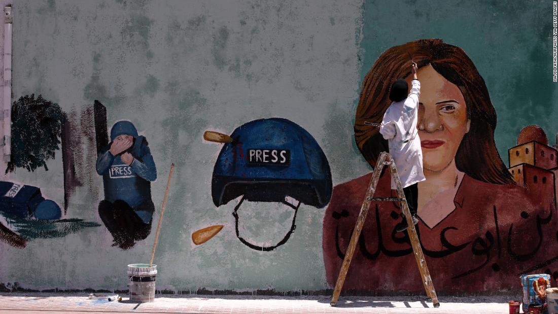 A Palestinian artist paints a mural in Gaza City honoring Shireen Abu Akleh, and depicting Shatha Hanaysha crouching beside her after she was killed. 