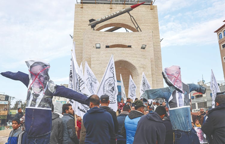  RAFAH (Gaza Strip): Protesters carry defaced posters depicting Israeli Prime Minister Benjamin Netanyahu (R) and far-right Minister of National Security Itamar Ben-Gvir during a rally held on Wednesday to condemn the latter’s visit to the Al-Aqsa mosque compound.—AFP 