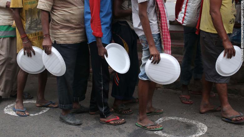 Underprivileged people wait to receive free food in Kolkata, India, on August 27, 2020.  