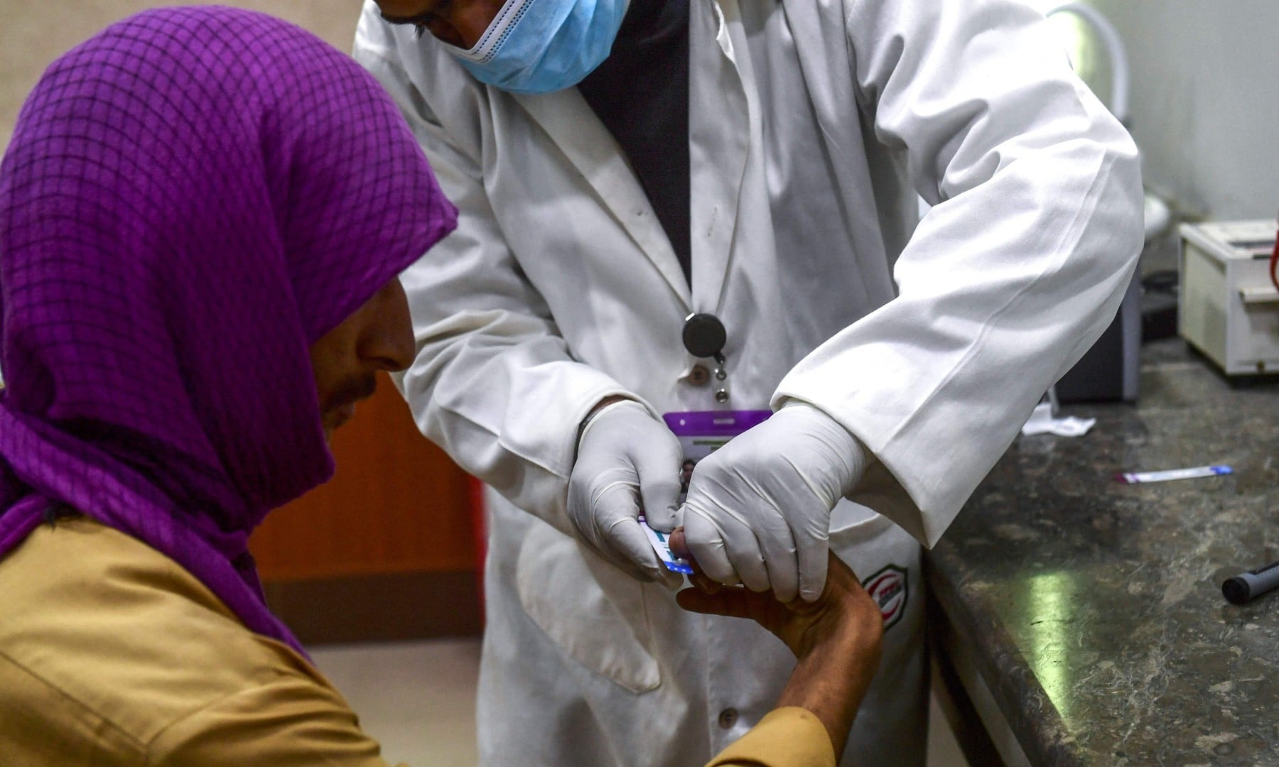 n this picture taken on March 26, a laboratory technician takes a blood sample from a man for an HIV test at a HIV treatment support centre in Ratodero. — AFP