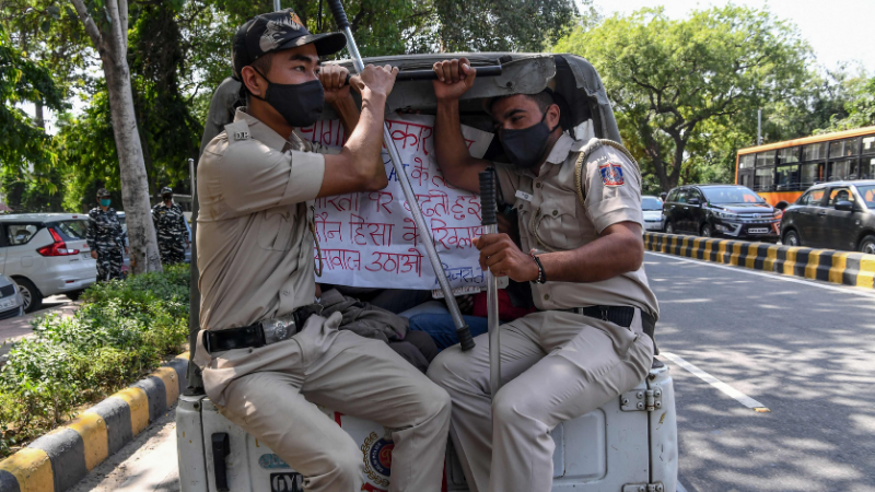 Police personnel sit in a vehicle after detaining protestors during a demonstration outside the Uttar Pradesh Bhawan (state house) in New Delhi on Sept 30, 2020, a day after a 19-year-old woman who was allegedly gang-raped died from her injuries near Bool Garhi village in the UP state. — AFP