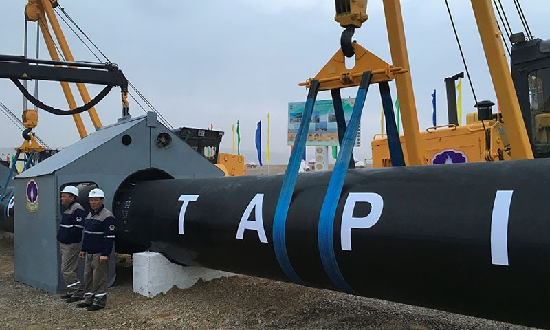 Workers stand near a gas pipe during the launching ceremony of construction work of the TAPI project on the Afghan section of a natural gas pipeline. — Reuters/File