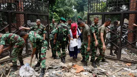 Reuters Members of the army clear an entrance of the Ganabhaban, the Bangladeshi prime minister's residence, a day after the resignation of Prime Minister Sheikh Hasina, in Dhaka, Bangladesh, August 6, 2024.