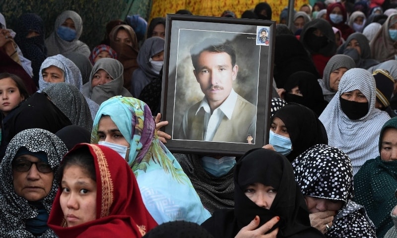 A mourner from the Shia Hazara community holds the portrait of a victim during a sit-in on the outskirts of Quetta. — AFP