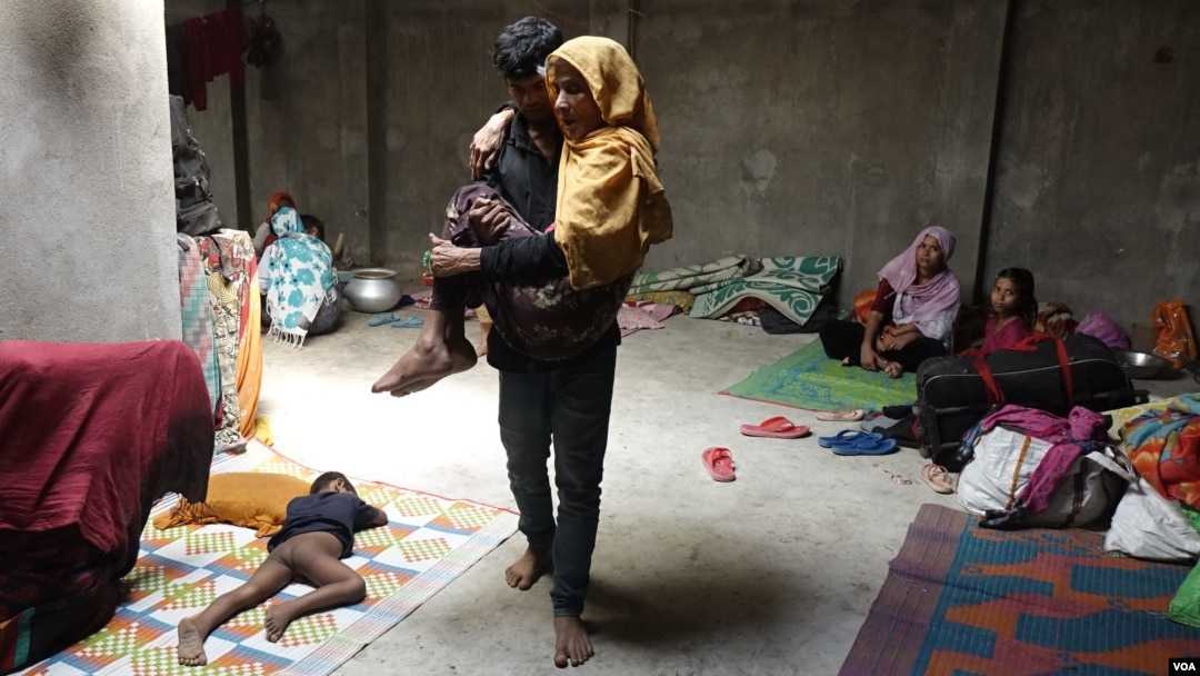 FILE - A Rohingya refugee man carries a sick, elderly community member inside a makeshift refugee camp somewhere in India, Nov. 27, 2018. To avoid detention, Rohingya refugees often move from one place to another and live in makeshift refugee camps. (Shaikh Azizur Rahman/VOA)