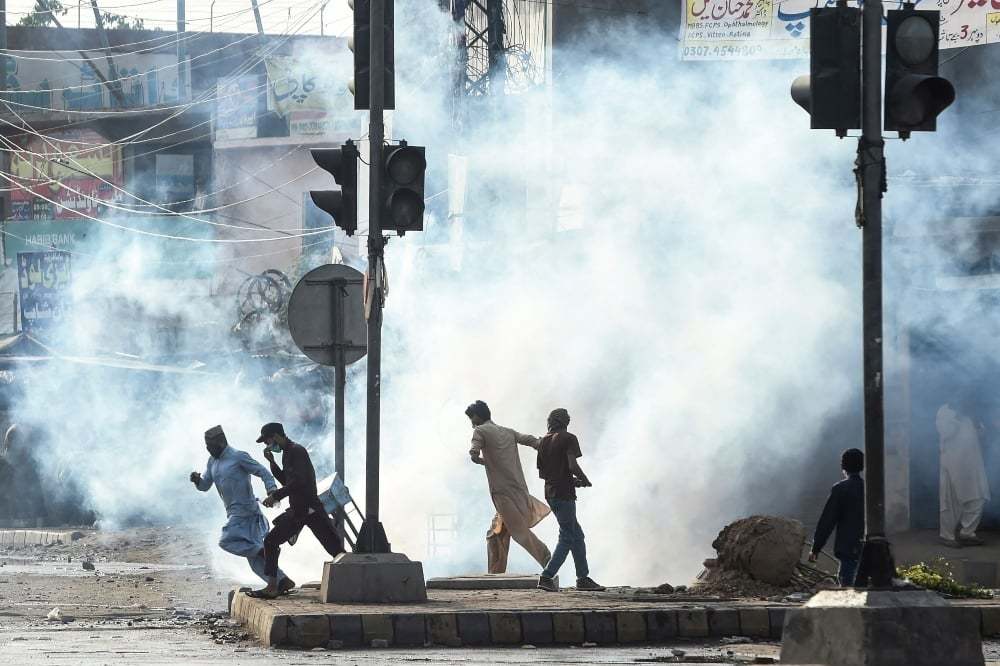 Supporters of the recently proscribed Tehreek-i-Labbaik Pakistan disperse after police fired tear gas during a protest in Lahore on April 13. — AFP/File