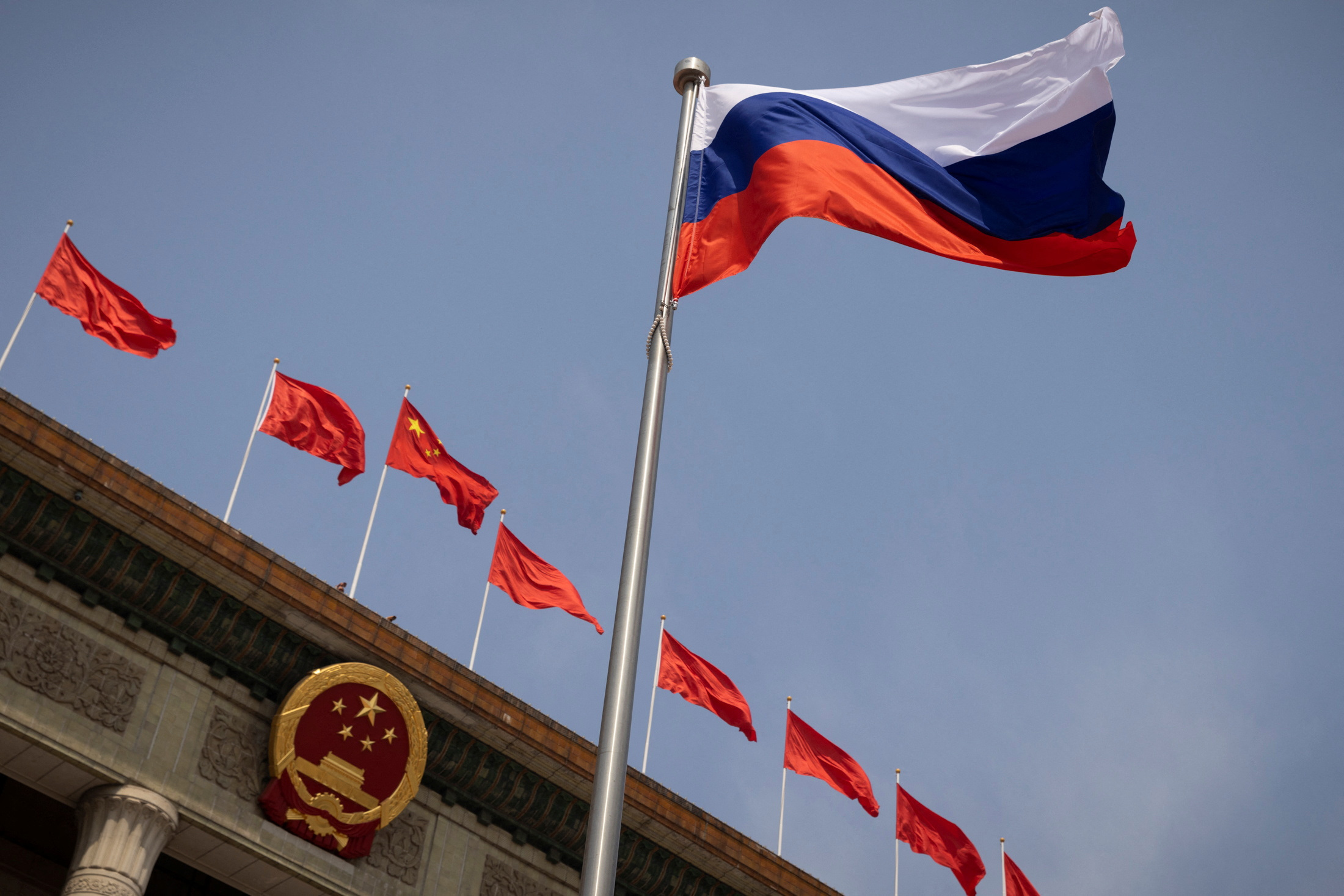 The Russian national flag flies in front of the Great Hall of the People before a welcoming ceremony for Russian Prime Minister Mikhail Mishustin in Beijing