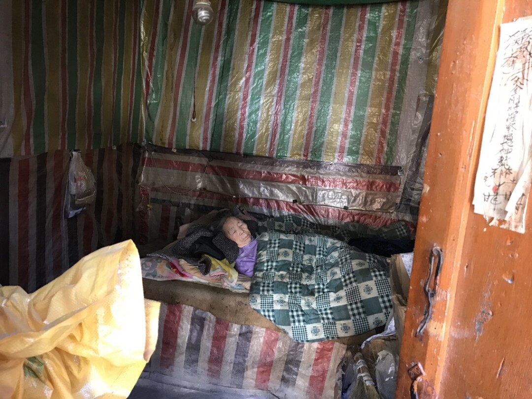 Yuan Juxiu, 84, lies bedridden in her village home.