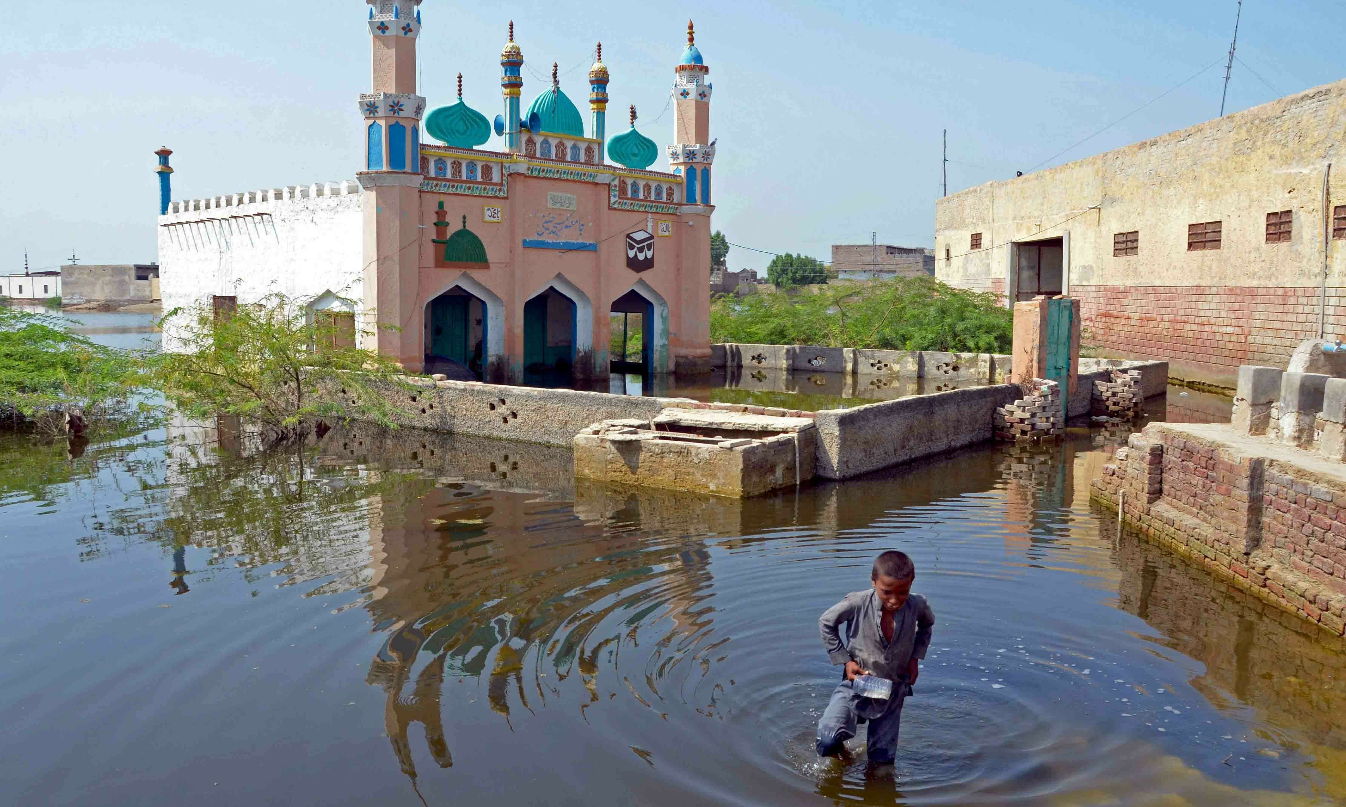 <p>A boy wades through flood waters at Sohbatpur in Jaffarabad district of Balochistan province on September 19. — AFP</p>