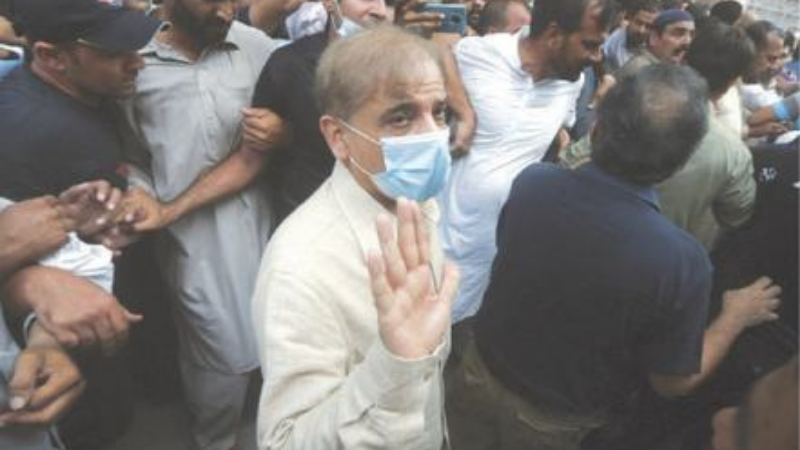 In this file photo, Opposition Leader Shahbaz Sharif waves while being escorted by officials at the Lahore High Court after his bail was rejected on Sept 28. — AP