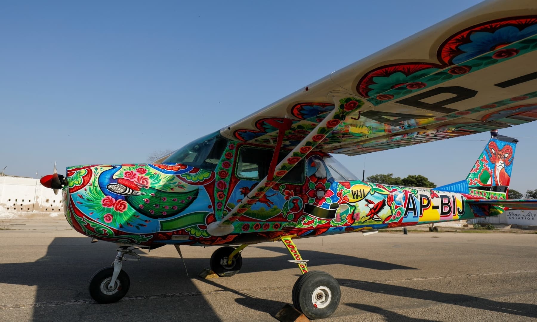 A two-seater Cessna aircraft painted with Pakistani truck art is seen at Jinnah International Airport, Karachi, Dec 30, 2020. — Reuters