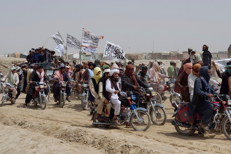 Supporters of the Taliban carry their signature white flags after they seized the Afghan border town of Spin Boldak [File: Tariq Achkzai/AP Photo]