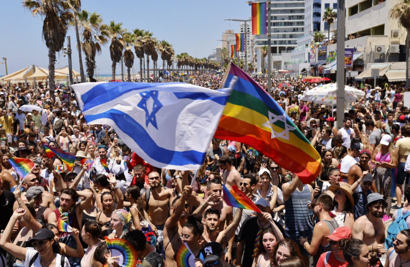 Israeli flag and rainbow flag being waved at Tel Aviv Pride Parade, June 25 2021 (photo credit: GUY YECHIELY)