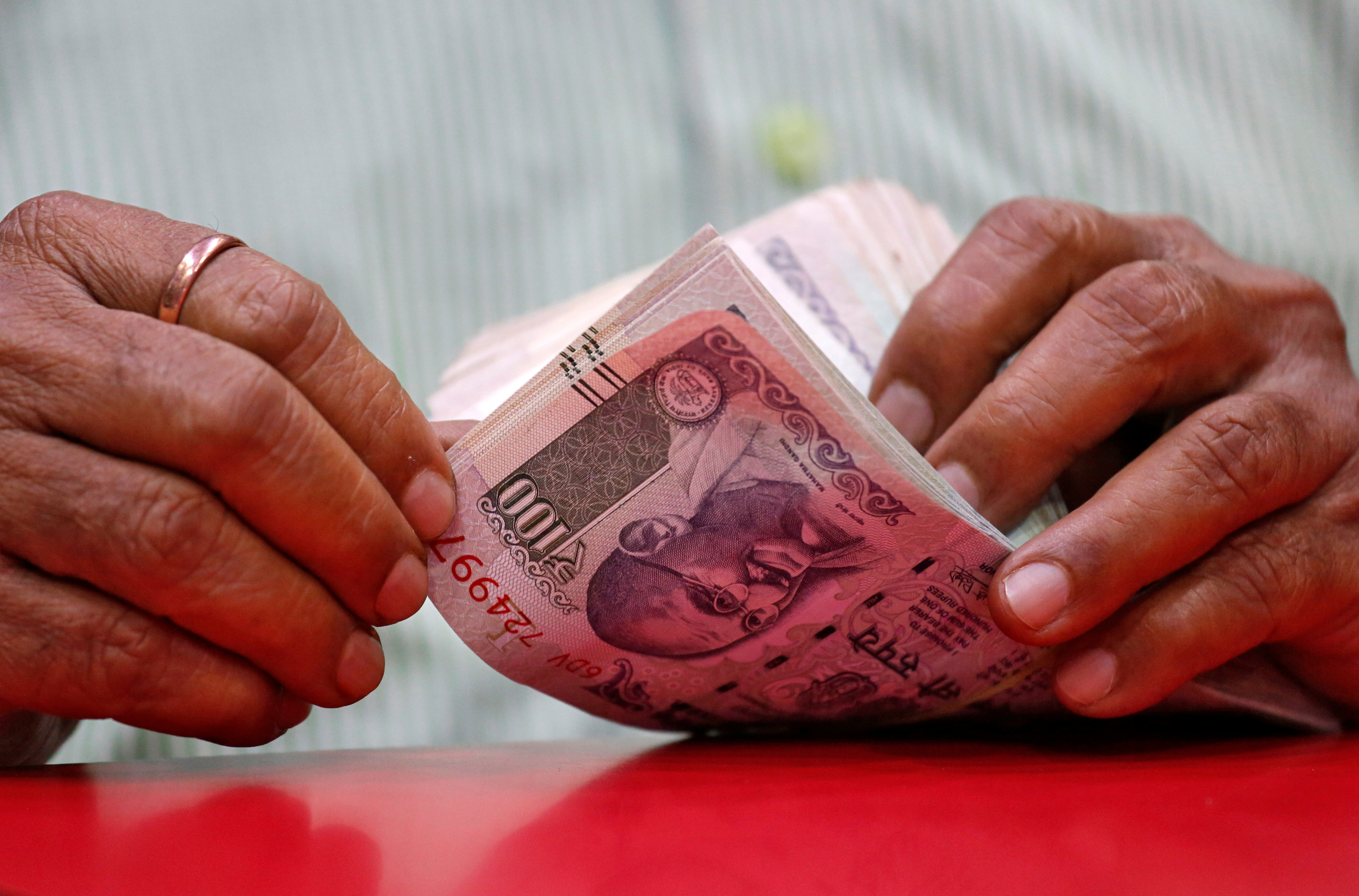 A man counts Indian currency notes inside a shop in Mumbai