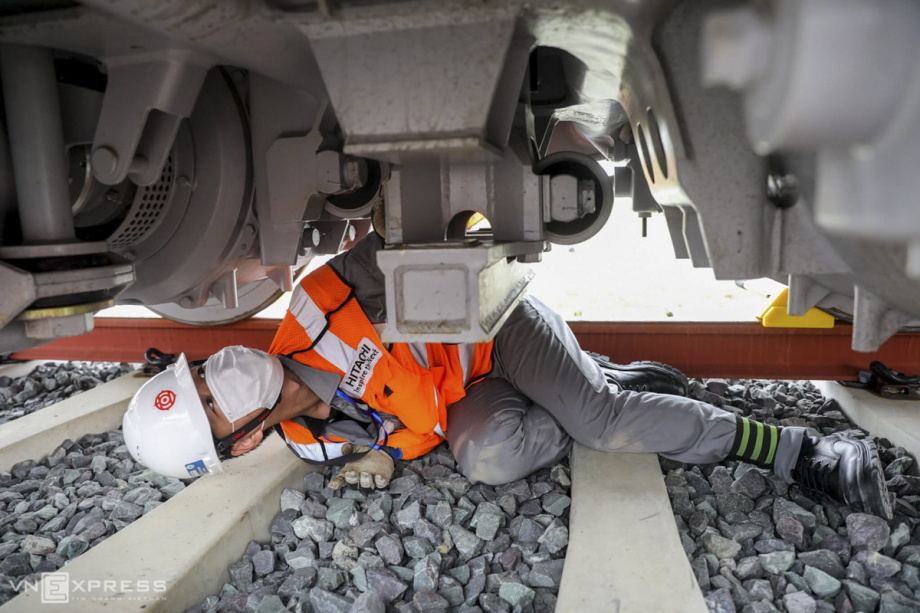 A Japanese expert lies under the coach to check the technical system. In the coming time, the contractors will construct and install the power line to prepare for the test run.