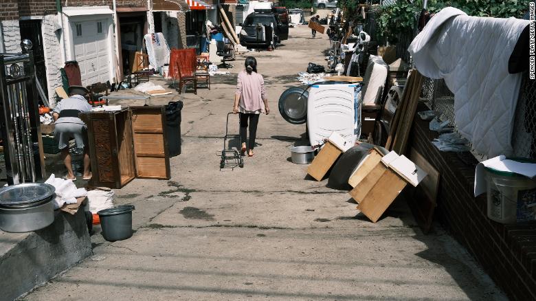 People clean up their flooded homes in a Queens neighborhood that saw massive flooding and numerous deaths following a night of heavy wind and rain from the remnants of Hurricane Ida on September 03, 2021 in New York City. 