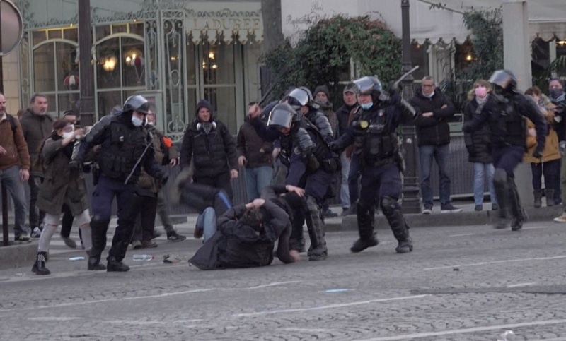 Riot police use their batons as they scuffle with demonstrators on the Champs-Elysees avenue during a protest against Covid-19 vaccine and restrictions, in Paris, France on February 12, 2022. — AFP