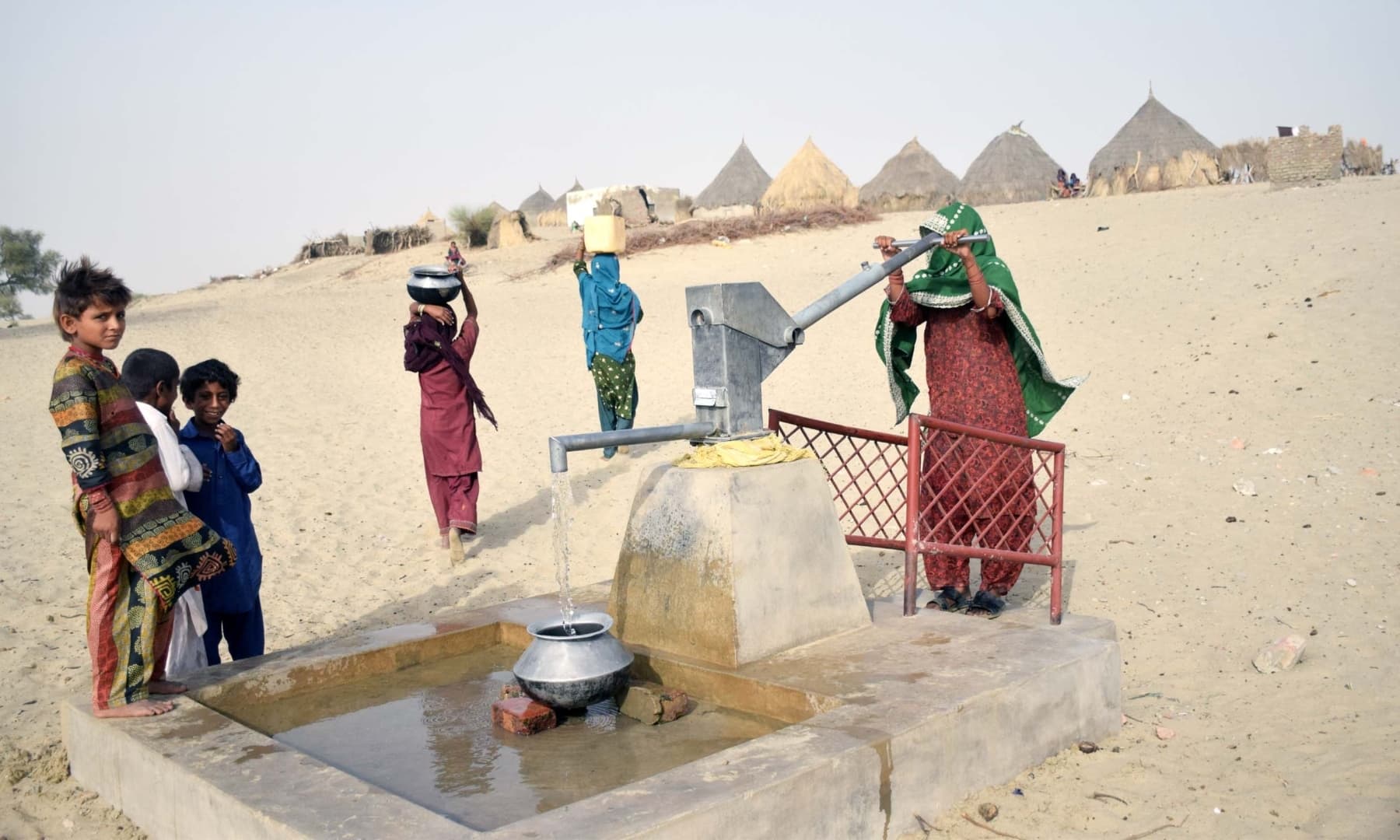 Women and children fetch water from a well in Achhro Thar, Khipro, Sindh. — Photo by Umair Ali