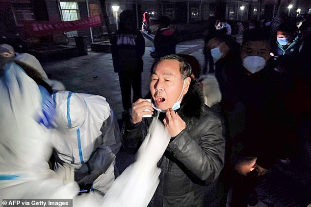 The Chinese city of Anyang entered lockdown today, forcing its five million residents to stay inside their homes as the country battles Covid-19 outbreaks. Pictured: Residents queue to undergo nucleic acid tests for the Covid-19 in Anyang, January 8, 2022