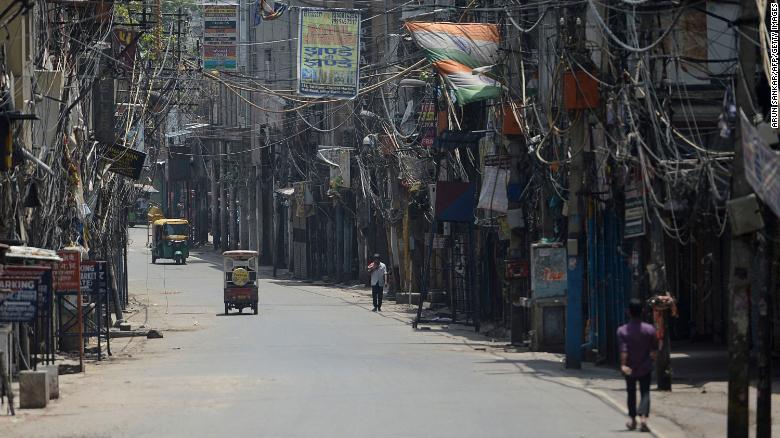 People walk through a deserted alley during a lockdown imposed by the government amid rising Covid-19 cases, in New Delhi on May 16, 2021. 