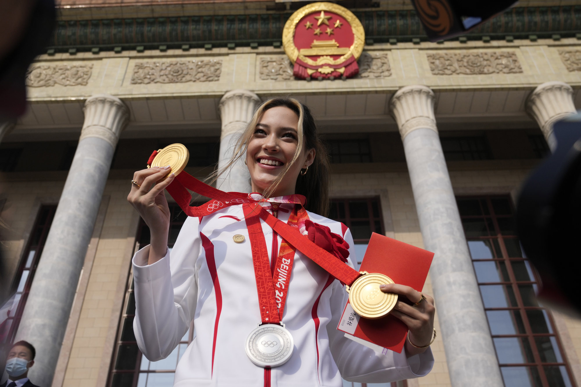 China’s Eileen Gu poses with her three Olympic medals before a commendation ceremony at the Great Hall of the People in Beijing. Photo: AP