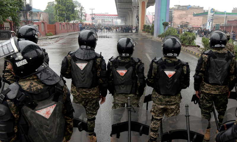 Security personnel stand at Murree Road to prevent violence by TLP activists camped at Faizabad. — Mohammad Asim/White Star