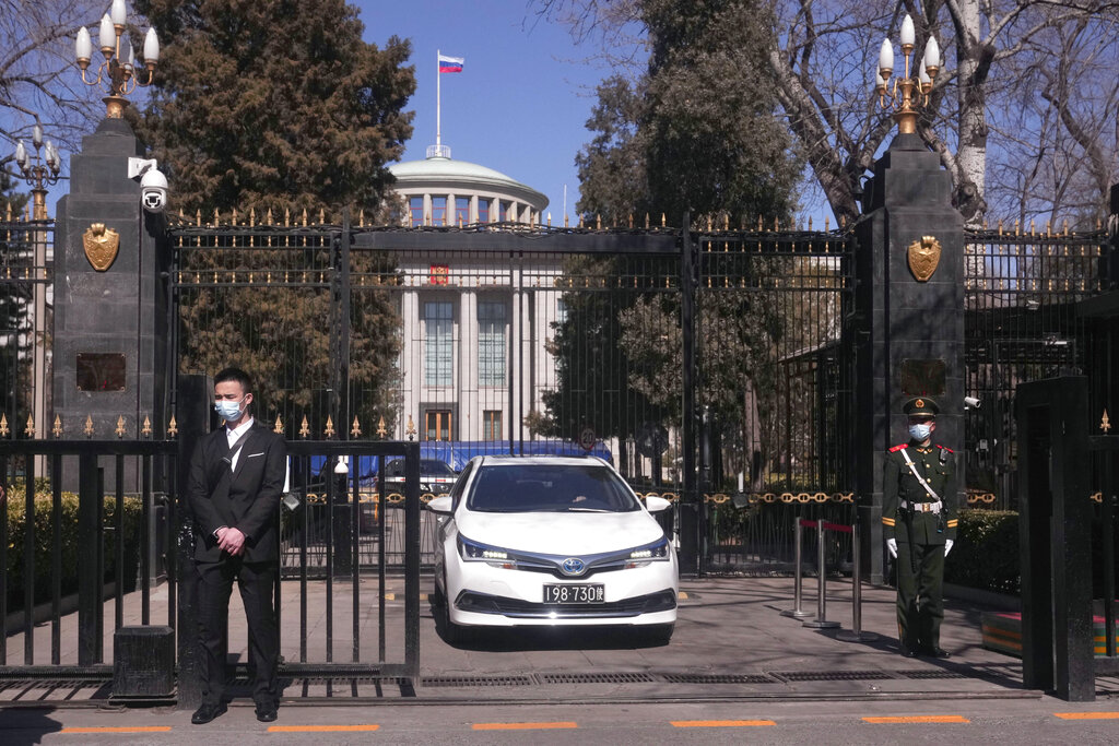 A plainclothes security person keeps watch outside the Russian Embassy in Beijing on Tuesday, March 1, 2022. (AP Photo/Ng Han Guan)