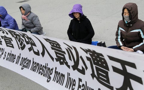 Practitioners of Falun Gong, meditate and exercise outside of the Chinese consulate, Thursday, April 25, 2019, in New York