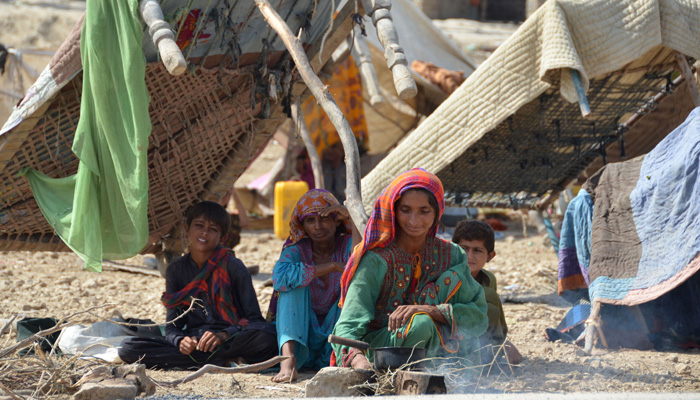 A displaced flood-affected family sits under the shade of a cot bed at Dera Allah Yar in Jaffarabad district of Balochistan province on September 20, 2022.—AFP