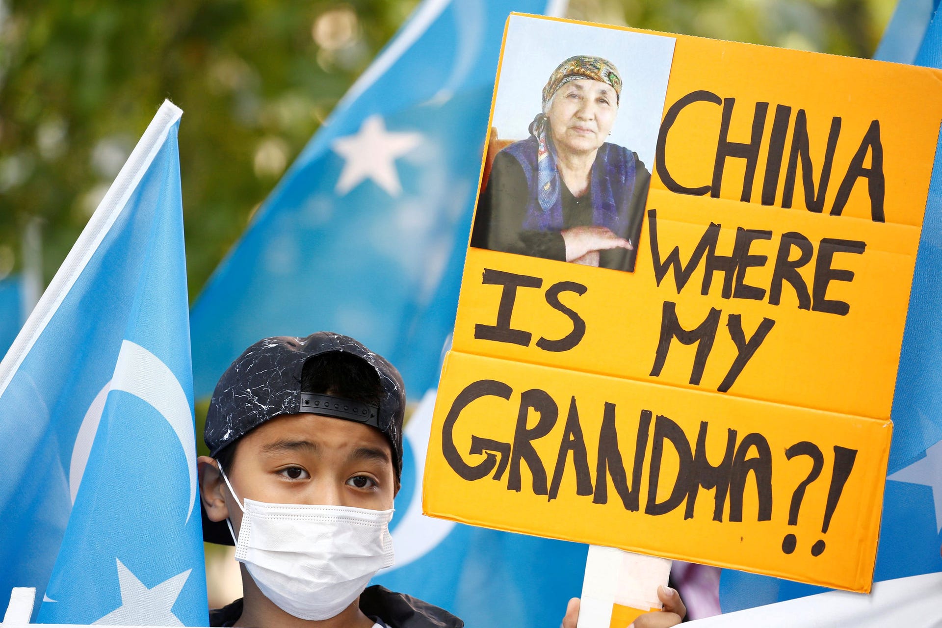 A child holding a banner among Uighur flags at a rally during Chinese Foreign Minister Wang Yi's visit in Berlin, September 1, 2020. 