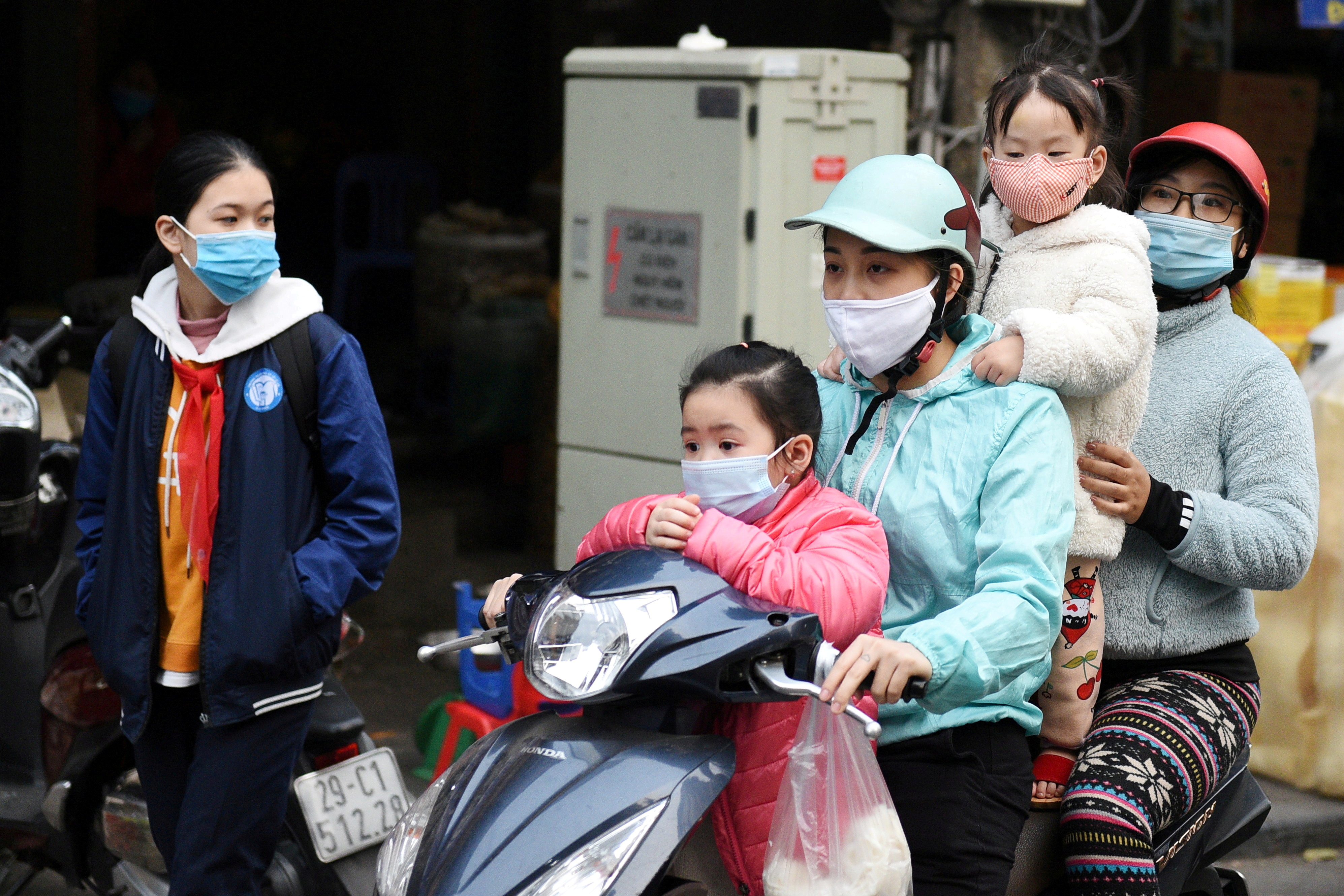 A family wears protective masks as they ride a motorbike in the street amid the coronavirus disease (COVID-19) outbreak in Hanoi, Vietnam, January 29, 2021. REUTERS/Thanh Hue